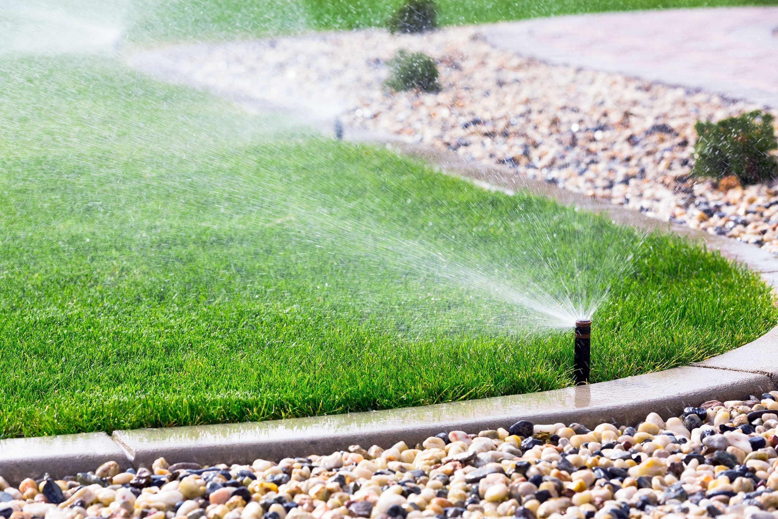 Home irrigation watering a landscaped lawn
